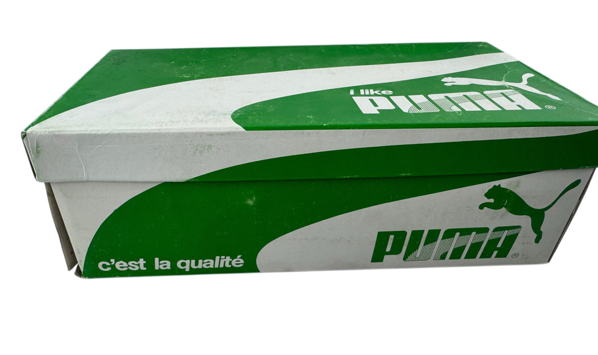 A green and white Puma shoebox with the Puma logo and 'c'est la qualité' text printed on the side, set against a plain white background.