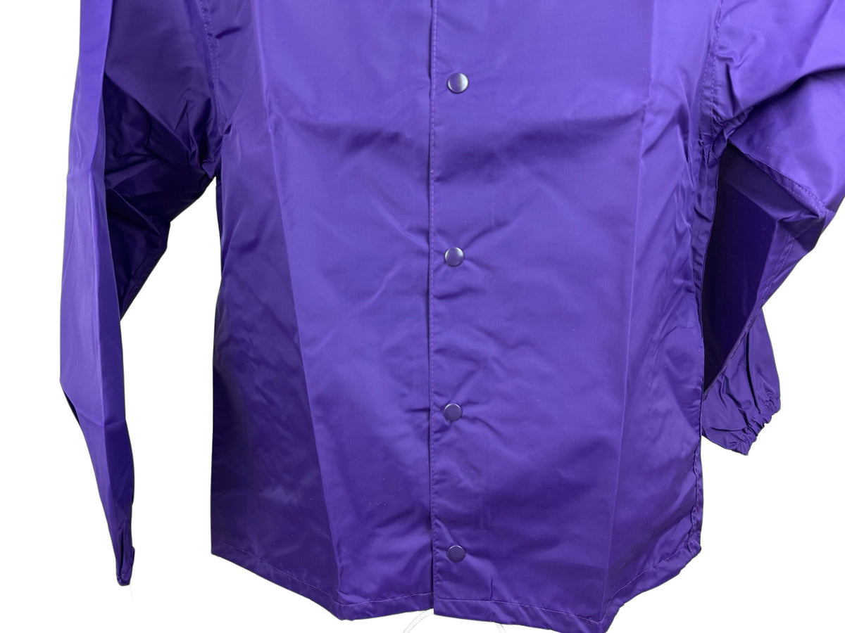 A close-up of a purple snap-front  nylon jacket with long sleeves, shown against a plain white background.