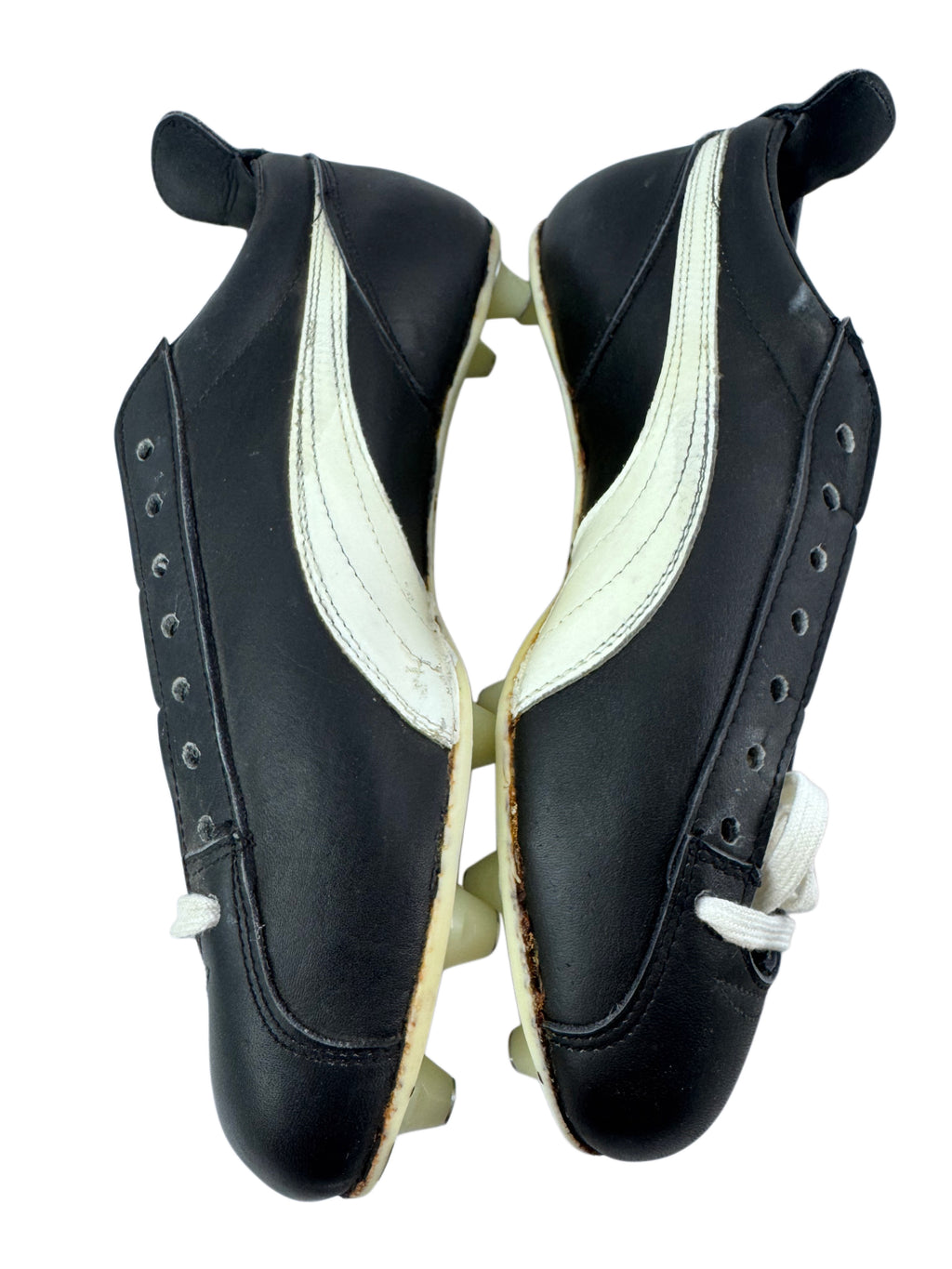 A pair of vintage black leather racing shoes with white side stripes and white laces, shown from a top-down view on a white background.