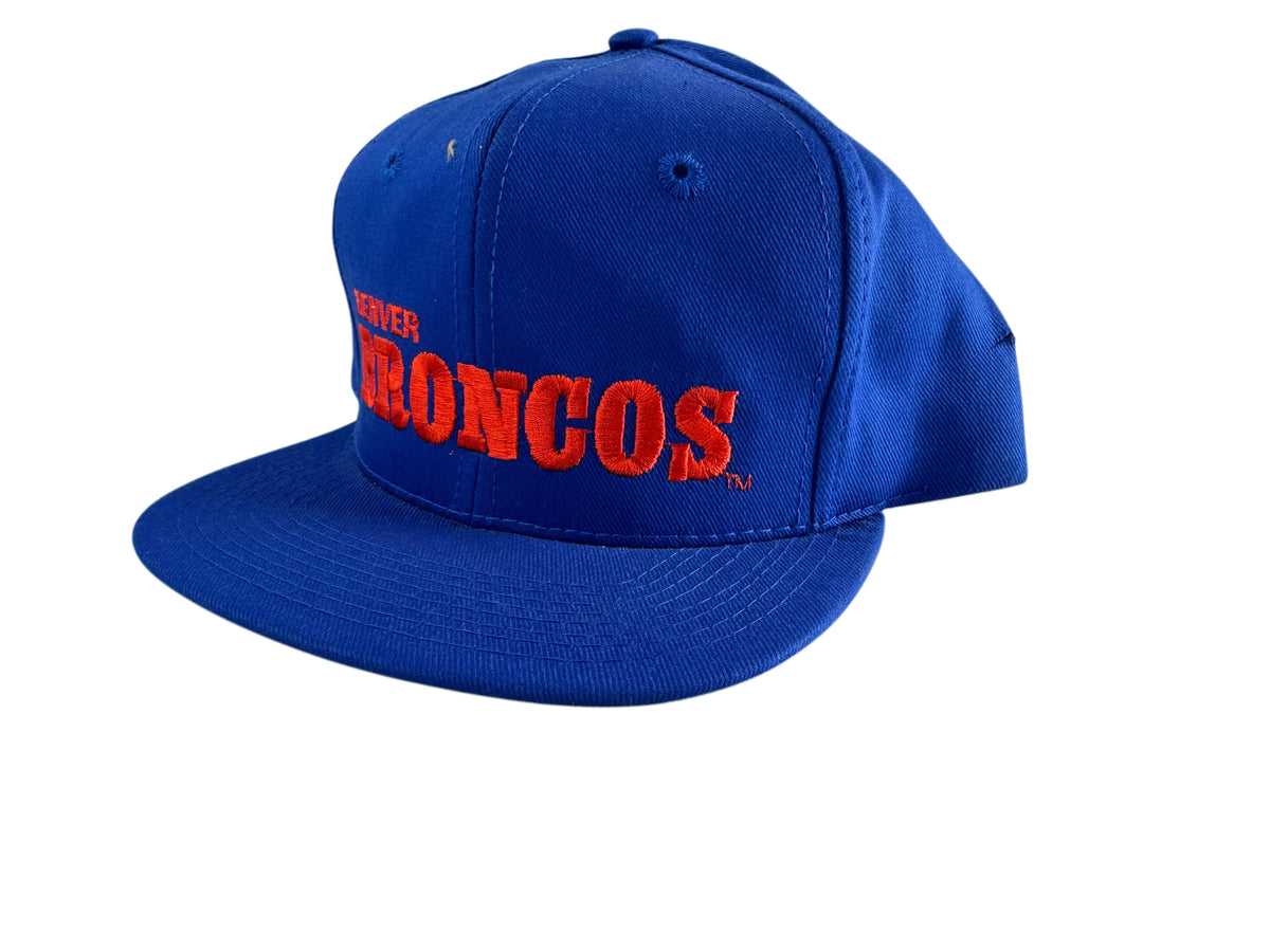A royal blue snapback cap featuring 'Denver Broncos' embroidered in red across the front, shown against a plain white background.