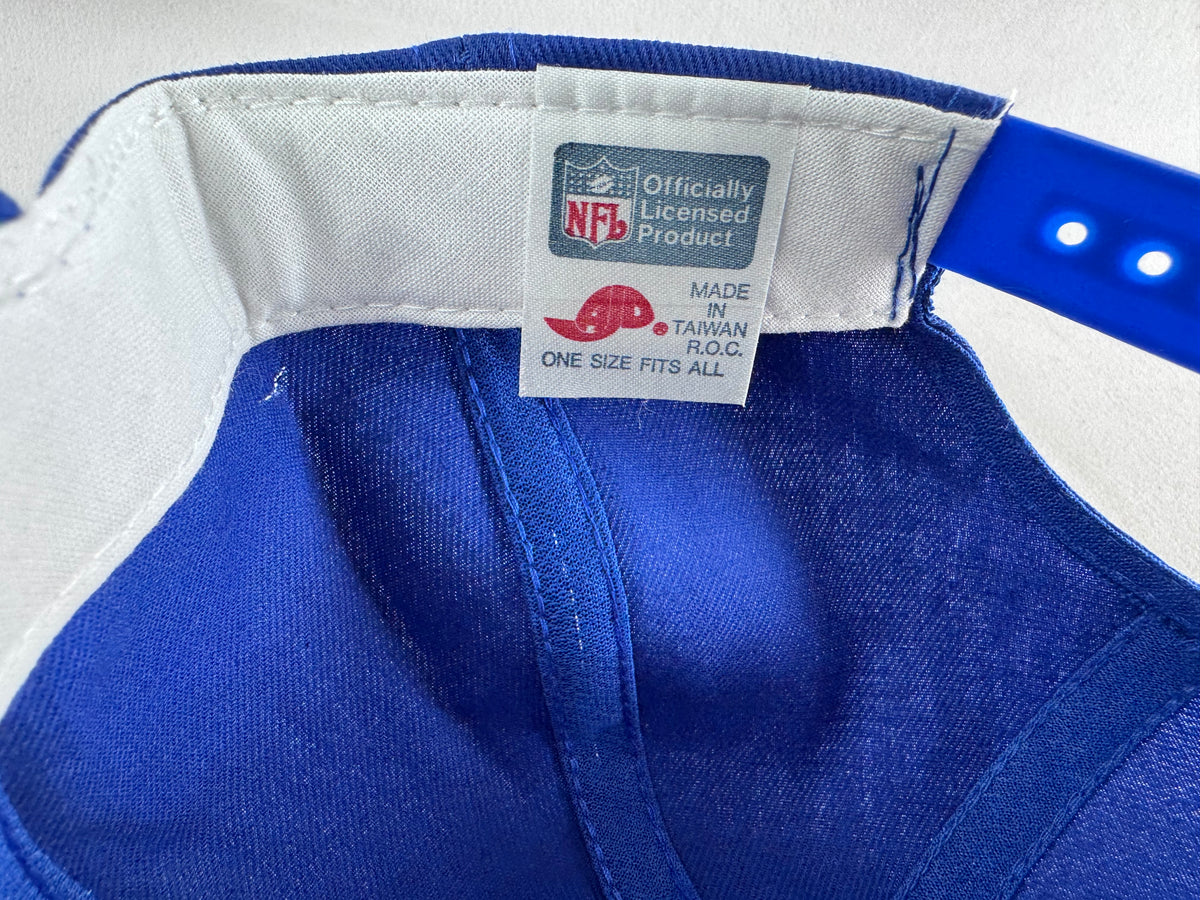 Close-up of the inside of a royal blue cap showing the NFL officially licensed product tag and white sweatband.
