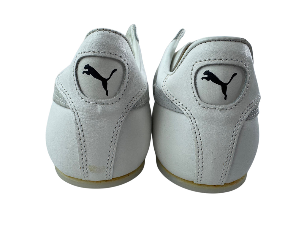 A pair of white Puma sneakers shown from the back, featuring the iconic black leaping cat logo on the heel counters, set against a plain white background.