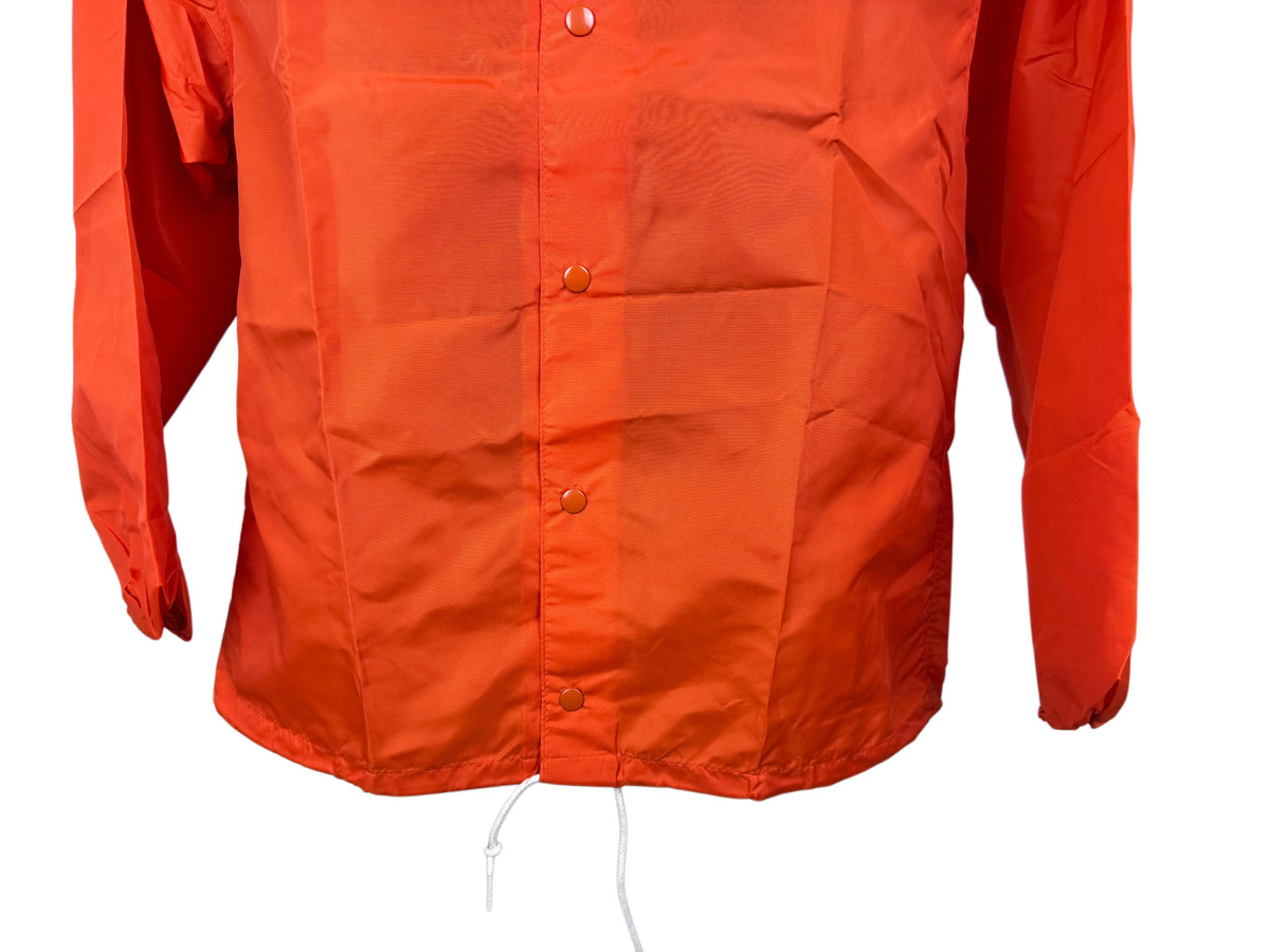 Bright orange lightweight long-sleeve snap-front closure nylon jacket with a drawstring hem, shown against a plain white background.