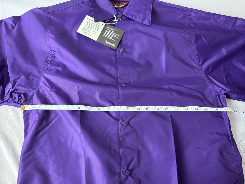 A purple lightweight jacket laid flat on a white surface, with a white measuring tape running across the chest and a hangtag attached near the collar.