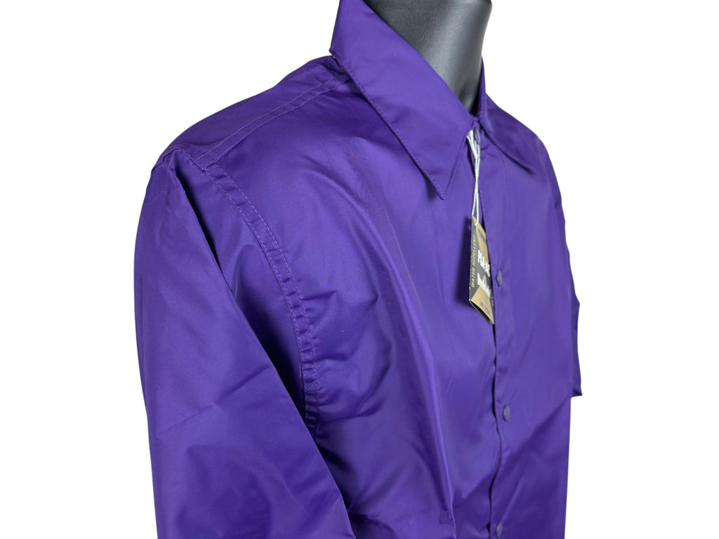 A close-up of a purple long-sleeve snap-front closure nylon jacket displayed on a dark gray mannequin torso against a white background.