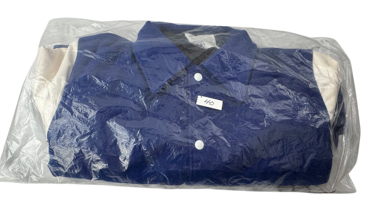 A folded blue and white lettermen's jacket enclosed in a clear plastic bag, photographed against a plain white background.