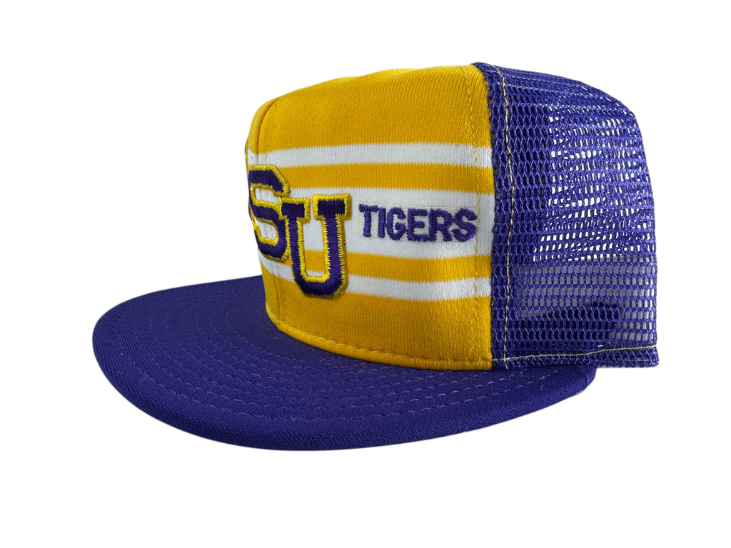 A yellow and purple trucker hat with a flat purple brim, featuring 'LSU TIGERS' embroidered on the front panel with yellow and white stripes.