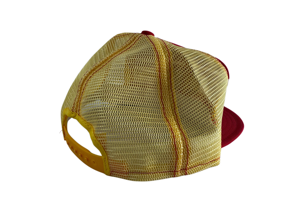 A gold mesh-back baseball cap with a red visor and red button on top, shown from a three-quarters angle against a white background.