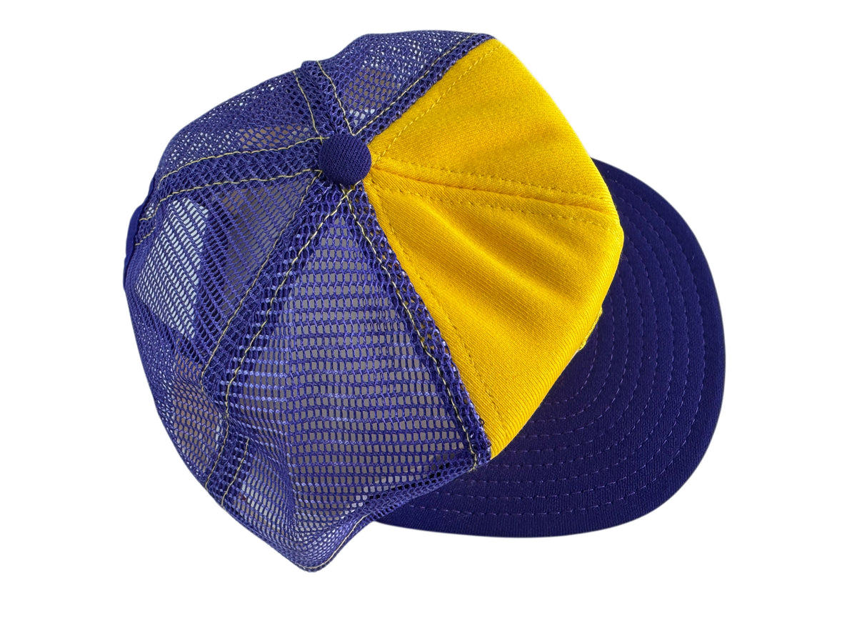 A two-tone trucker-style baseball cap with a yellow front panel and a purple mesh back and visor, shown on a plain white background.