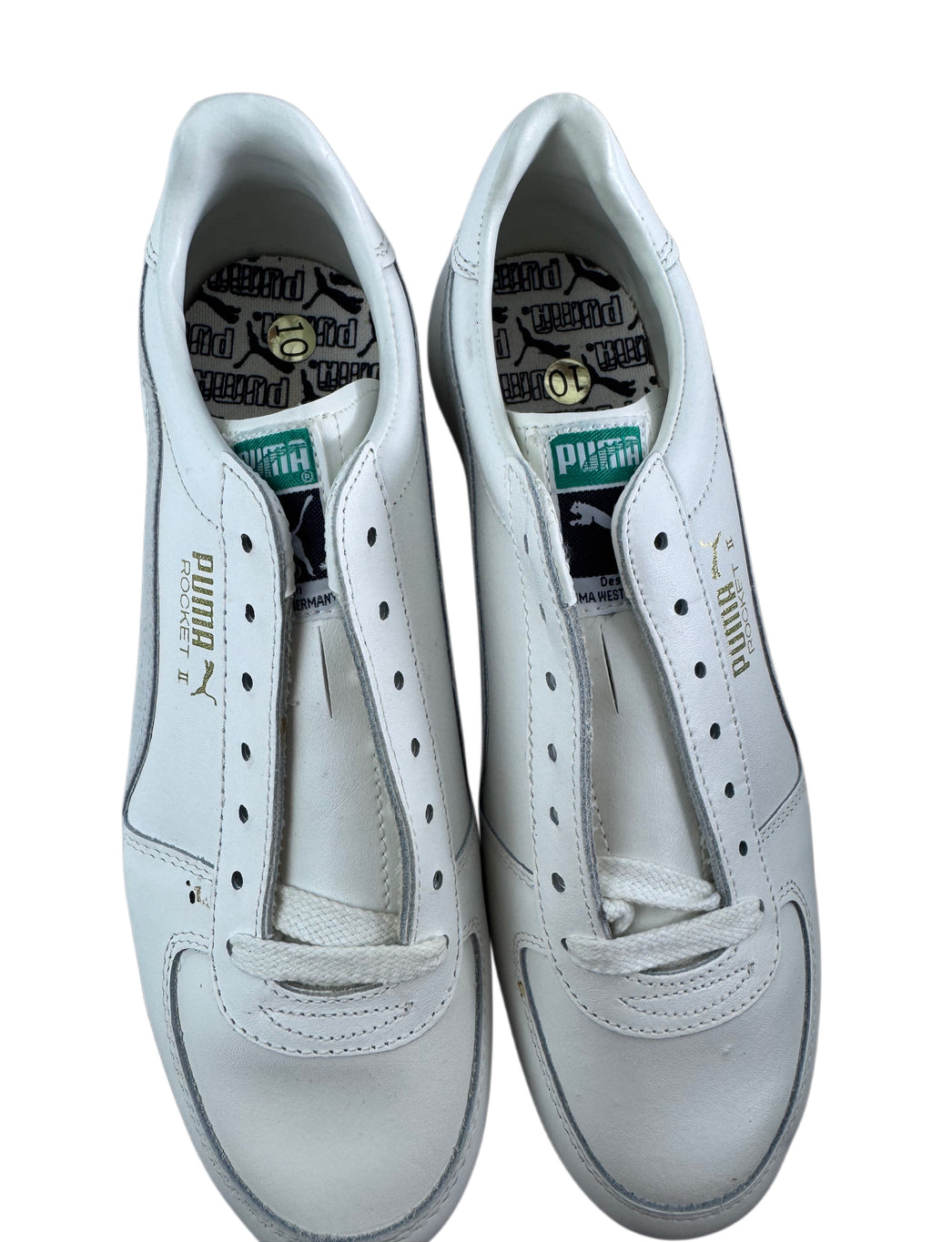 A pair of white Puma sneakers shown from a top-down view on a plain white background.