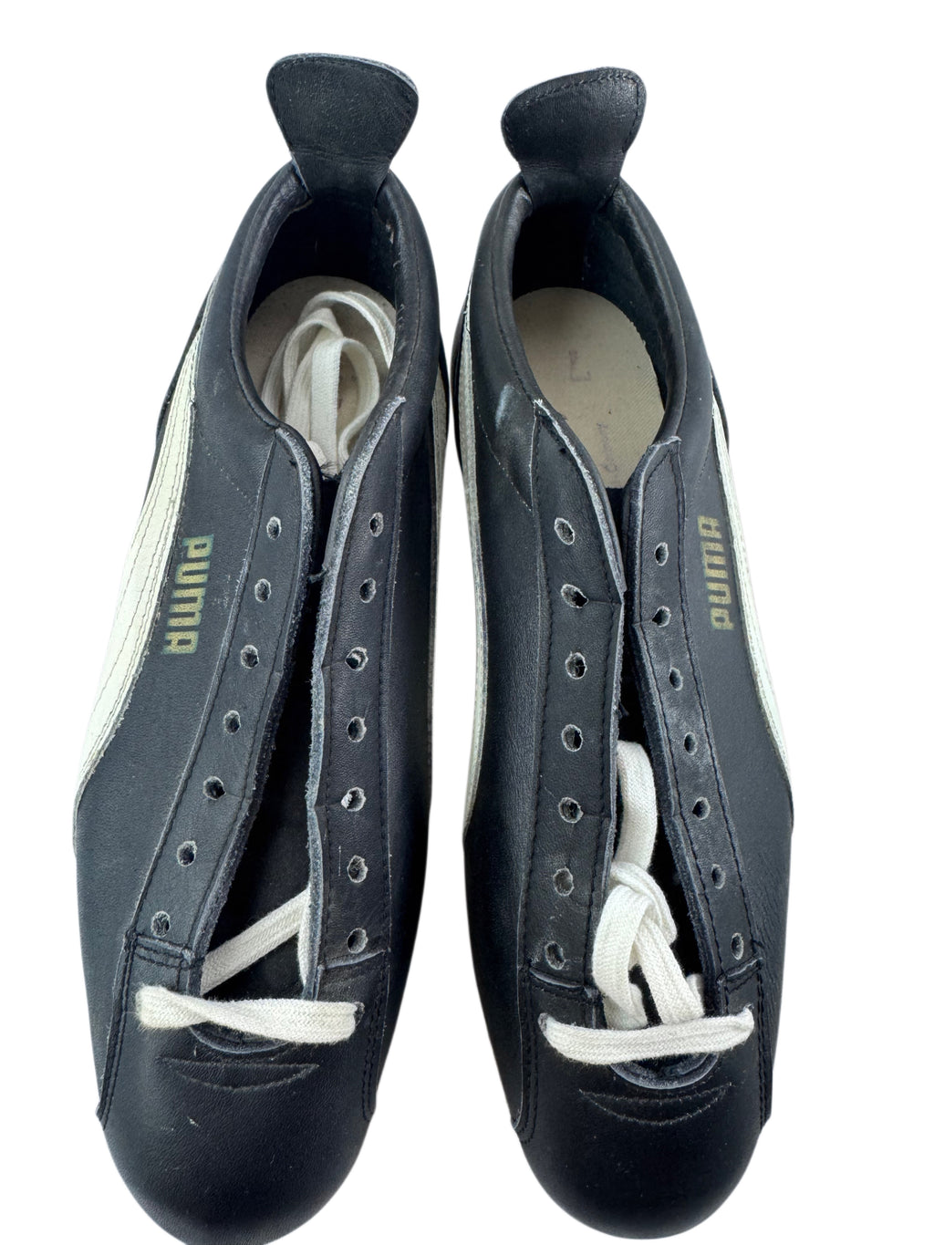 A pair of black Puma soccer/football shoes with white laces and white side stripes, photographed from above on a white background.