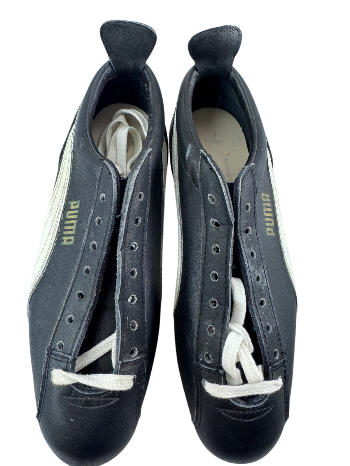 A pair of black Puma soccer/football shoes with white laces and white side stripes, photographed from above on a white background.